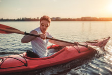 Man Kayaking On Sunset
