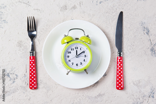 Zdjęcie XXL Budzik z dzwonami na talerzu z rozwidleniem i nożem, lunchu czasu pojęcie, odgórny widok z kopii przestrzenią