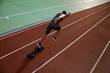 © Drobot Dean - Young african male runner running on racetrack