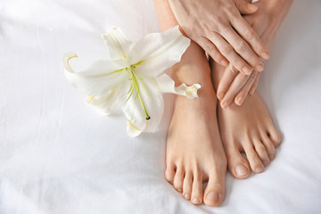  Female legs with flower on white fabric. Epilation concept