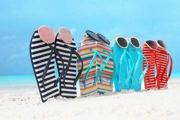 Sticker - Colorful flip-flops and sunglasses on sea shore. Summer vacation concept