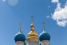Golden Domes Of The Russian Сhurch Against A Blue Sky With Clouds
