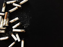 Cigarette Butts On A Black Background With A Copy Space.