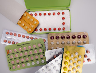 Wall Mural - Pile of birth control pills with modern packaging on white background