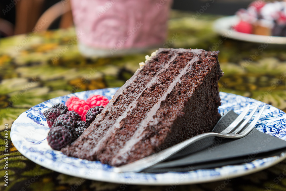 Obraz na płótnie Tort czekoladowy na talerzyku z owocami leśnymi w salonie