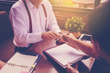 Businessman offering pen to his business partner for sign contract