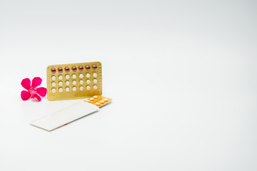 Wall Mural - Contraceptive pills with pink flower on white background