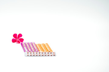 Wall Mural - Contraceptive pills with pink flower on white background