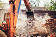 Details of backhoe excavator scoop demolishing ruins, destroying and loading debris