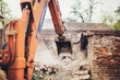 © aboutmomentsimages - Heavy duty Hydraulic crusher excavator backoe machinery working on site demolition