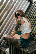 Young Tattooed Girl Skate Boarding Around Town.