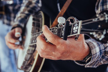 Musician's Hands Playing A Banjo At A Festival Outdoors