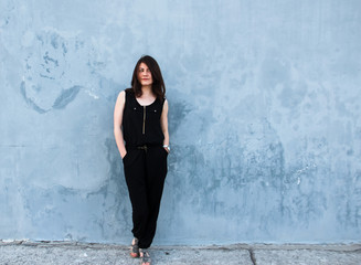 Young stylish girl in a black suit on a blue background