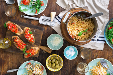 Wall Mural - Italian dinner table with pasta, appetizers and white wine