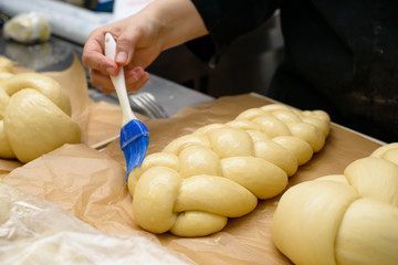 Wall Mural - female chef lubricate the bakery products with an egg yolk. Cooking time, cooking concept, selective focus