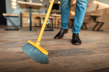 Cropped View Of African American Worker Sweeping With Broom In Coffee Shop