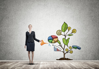 Young businesswoman in empty room watering drawn growth concept with can