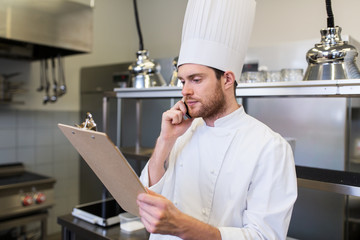 Canvas Print - chef cook calling on smartphone at restaurant kitchen