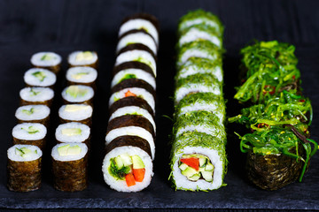 Vegetarian sushi menu. Rolls with cucumber, futomaki with vegetables and gunkan sushi with chuka salad.