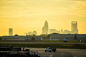 Wall Mural - sun rising early morning over charlotte skyline seen from clt airport