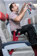 Shocked unfastened man on the plane during turbulence levitates. Accident passenger who is not fasten to the seat.