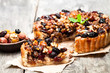 Delicious  tart with dried berries and nuts on old wooden table