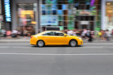 Fototapeta Miasta - Panning shot of a taxicab at Times Square in New York, USA.