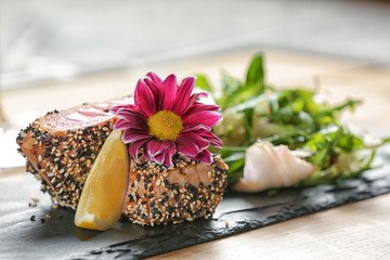 Slate plate with delicious tuna fillet on table