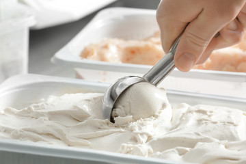 Wall Mural - Woman taking scoop of tasty yogurt ice cream, closeup