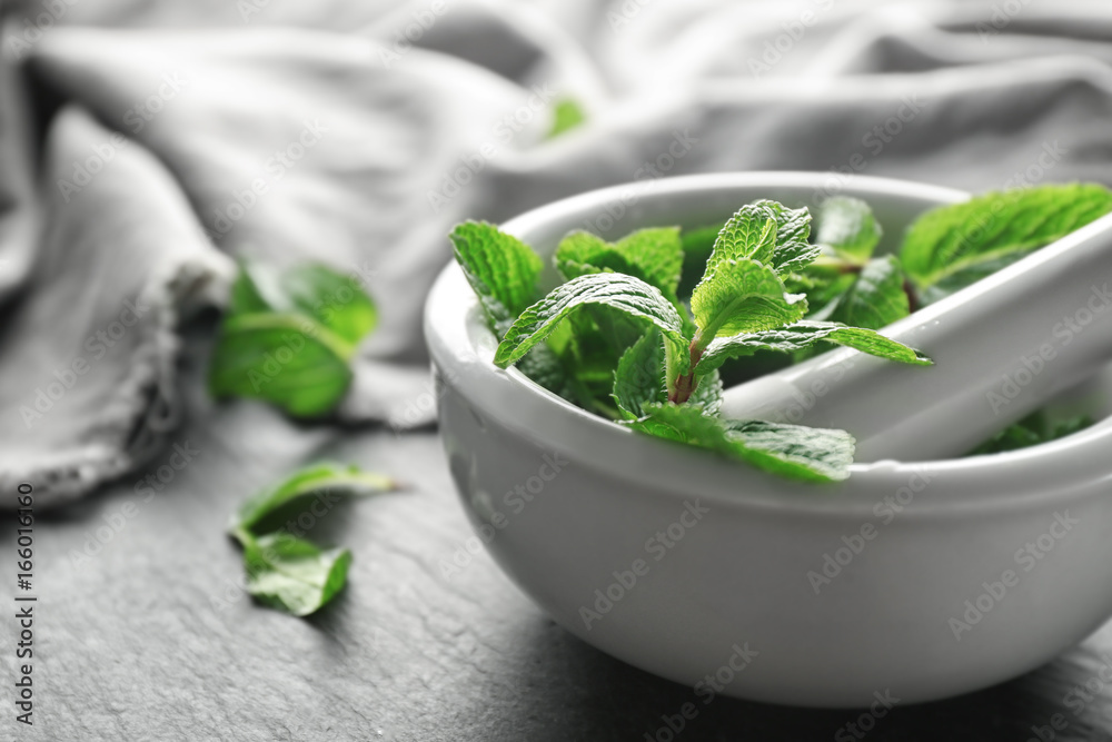 Mortar with fresh lemon balm leaves on table