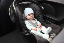 Cute Baby Boy Sitting In Safety Car Seat