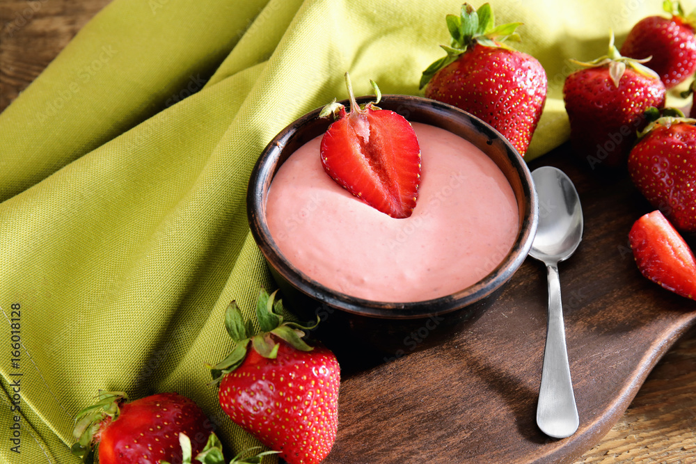 Composition with fresh homemade yogurt and strawberries on wooden table
