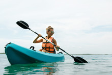 Happy Young Woman Kayaking On The Lake
