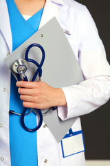 Wall Mural - Woman doctor standing with folder at hospital