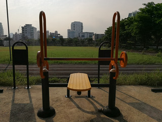 In evening people exercising outdoor with equipment at public park.