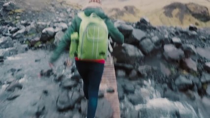 back view of the friends hiking on the mountain together. group of young people walking through the 