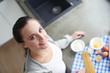 © lenets_tan - Beautiful woman cooking cake in kitchen standing near desk.