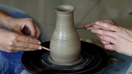 Wall Mural - Hands of two people create pot, potter's wheel. Teaching pottery