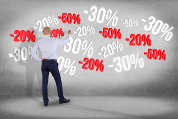 Poster - businessman in front of a wall with sales promotion 20% 30% and 50% flying on an interface - shoppin