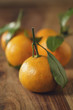 © GCapture - organic tangerines with leaves on wood table