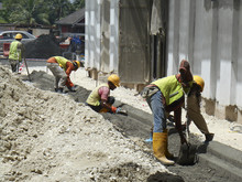 Construction Workers Fabricating Concrete Road Kerb At The Construction Site. They Are Using In Situ Method And Made And Using Metal Mold. 