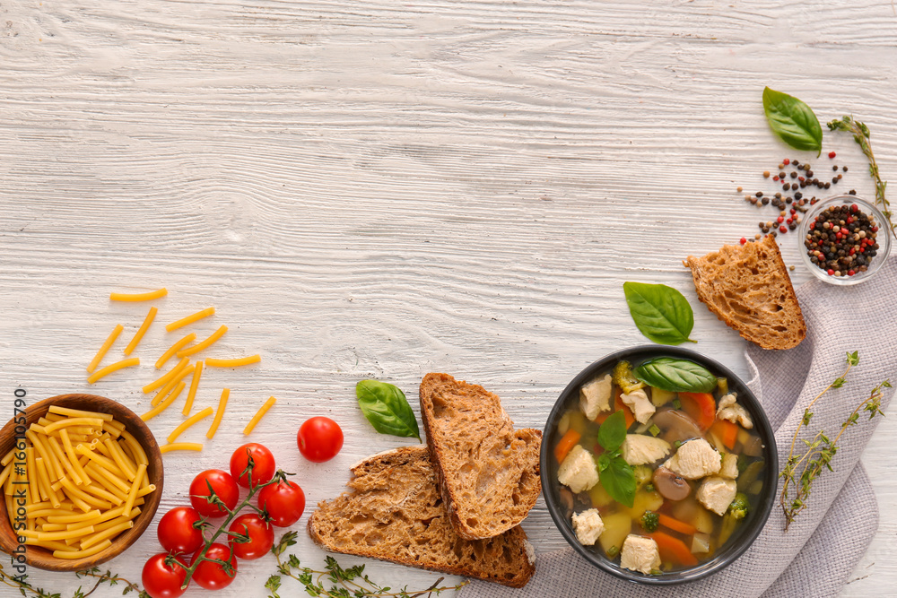 Bowl with delicious turkey soup on wooden background