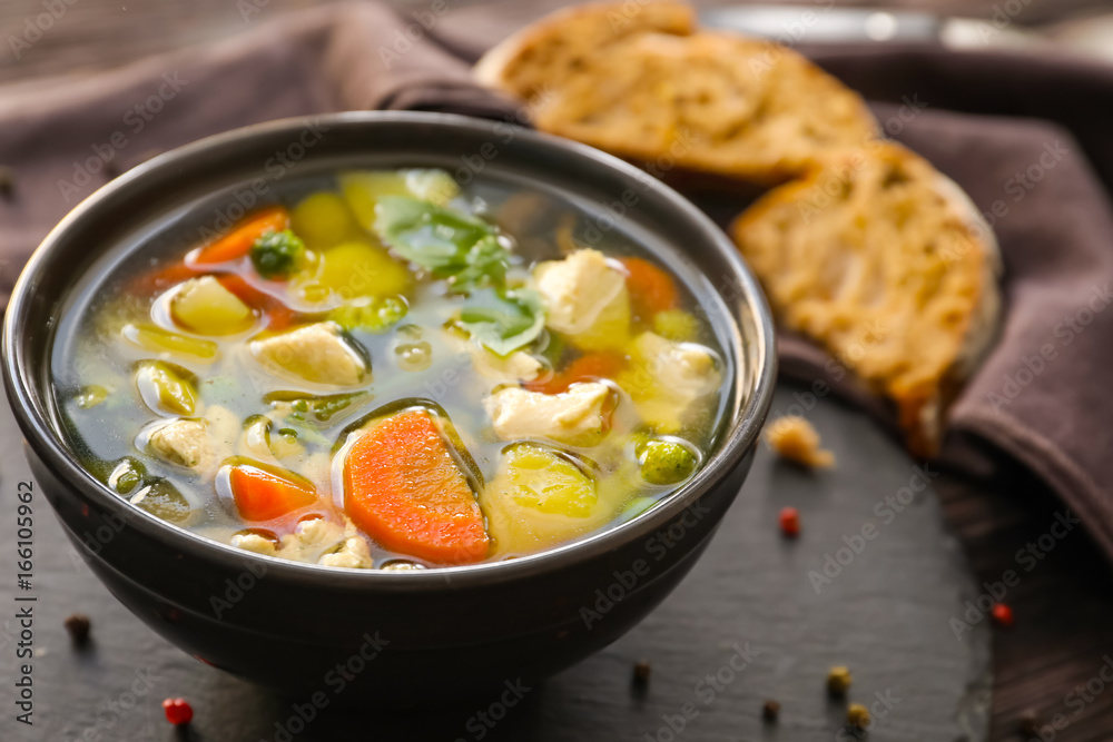 Bowl with delicious turkey soup on slate plate