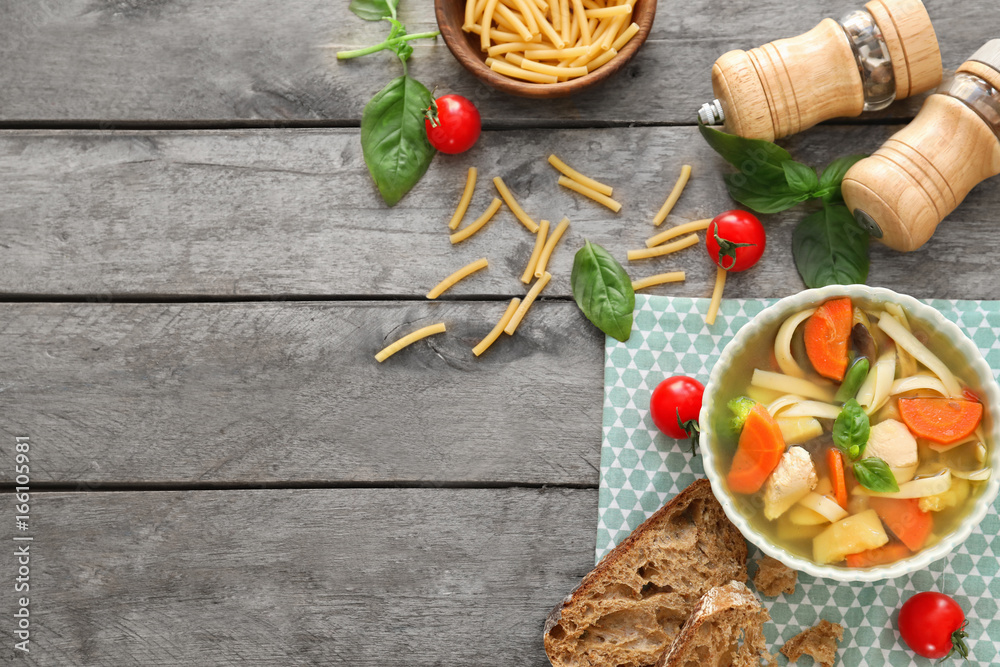 Bowl with delicious turkey soup on wooden background