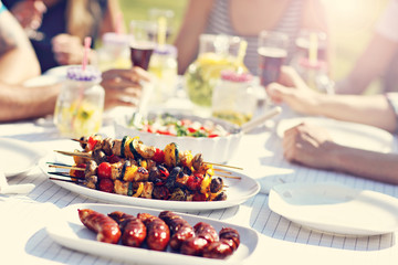 Friends having barbecue party in backyard