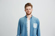 © Cookie Studio - Portrait of young handsome man in jean shirt smiling looking at camera over white background.