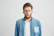 © Cookie Studio - Portrait of young emotive shocked man frowning looking at camera over white background.