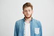 © Cookie Studio - Portrait of young emotive shocked man frowning looking at camera over white background.