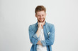 © Cookie Studio - Cunning tricky young man thinking looking in side with hand on chin over white background.