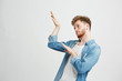 © Cookie Studio - Young positive handsome man in headphones listening to music dancing moving over white background.